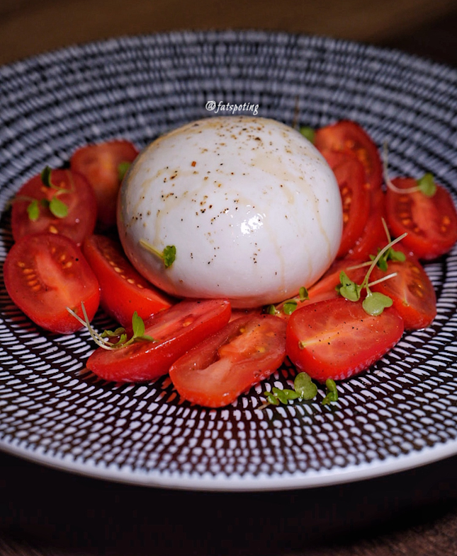 Artisanal burrata cheese with datterini tomatoes, apple balsamic, and calabrian oregano