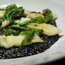 Squid ink risotto with fish slice & broccoli.