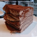 A slice of Chocolate Mille Crepe accompanied with Iced Butterscotch Milk..