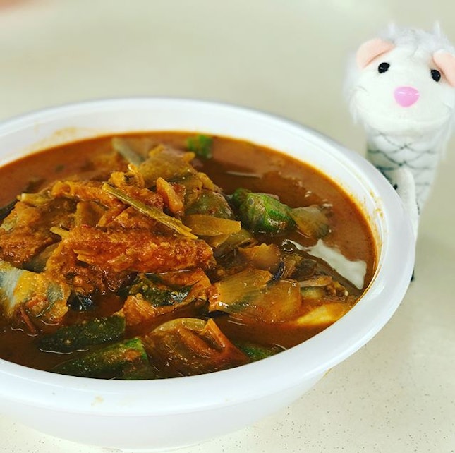 Assam Curry Fish Head - A pot of red snapper head in a fragrant pot of curry with assorted vegetables.