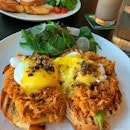 Open-faced sandwich with pulled pork and poached eggs