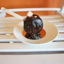A chocolate macaron lollipop.