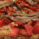 Bruschetta with tomatoes and anchovies.