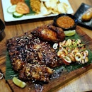 The Orang Dua Set comes with Bali Pork Ribs half rack, ayam panggang, squid bakar, bakwan jagung corn fritters, nasi goreng, goreng pisang (2 pcs).