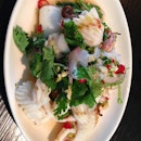 Pla Mauk Yung: Flash grilled squid & coriander salad dressed with green chili & lime.