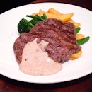 Char-grilled ribeye with "pink peppercorn", served with fries and spring vegetables.