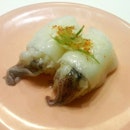 Cooked Squid Sushi very - tender and tasty, garnished with little spring onions and wasabi.