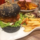 Salted Egg Chicken Burger(SGD$14.90) - crispy charcoal buns flanking crackling chicken thigh fillet topped with luscious salted egg sauce; salad and fries were served on the side.