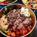 [Supergreek] - Grilled Steak ($13.90) uses a premium USDA choice roast beef, paired with house-made Tzatziki and hummus, and served with brown rice, arugula, lettuce, roasted broccoli and sweet potatoes with a sprinkle of sunflower seeds.