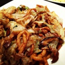 Fried noodles with shredded cabbage .